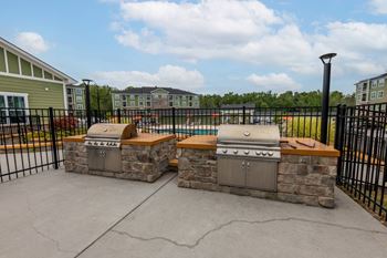 A stone fireplace with a black iron grate in front of a building at Foxwood Apartments, Raleigh-Durham